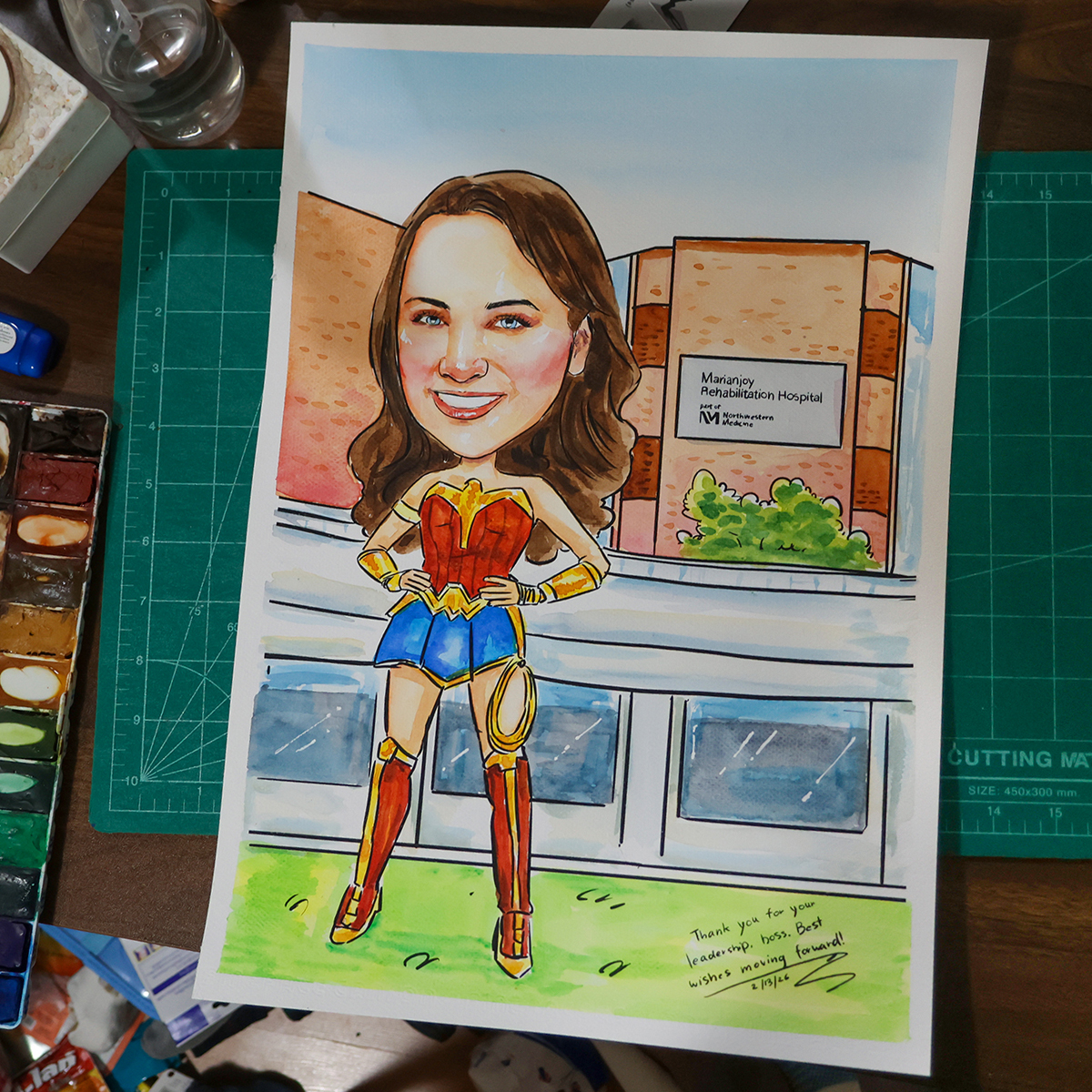 ภาพวาดการ์ตูนล้อเลียนสีน้ำ a3 ภาพวาดการ์ตูนล้อเลียนผู้หญิงชุดวันเดอร์วูแมน ยืนหน้าตึกโรงพยาบาล งานวาดมือสีน้ำบนกระดาษ